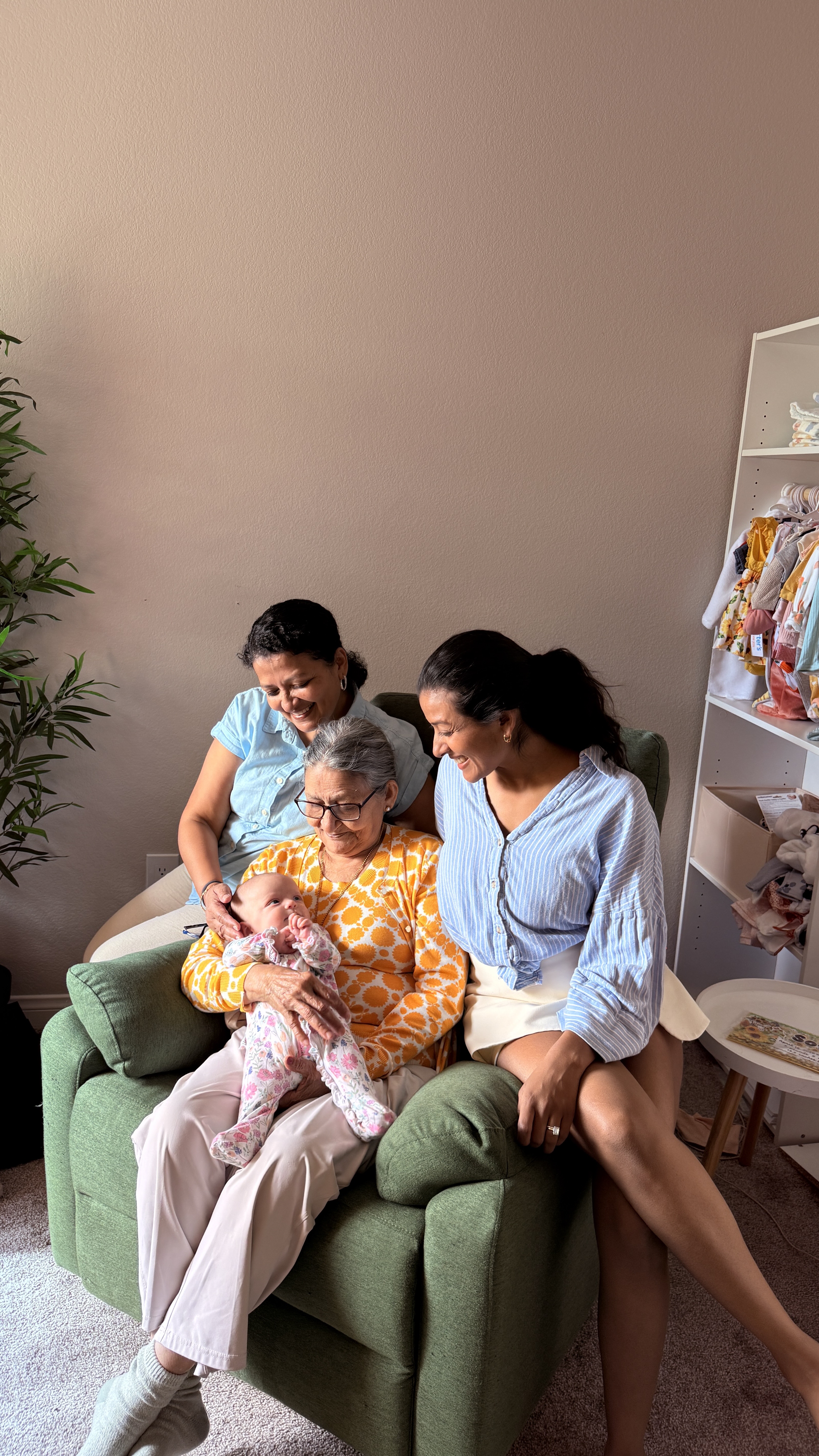 Four generations of family together, with a great grandmother, grandmother, and mother gathered around a newborn baby